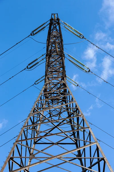 Alta tensão Eletricidade pilão contra o céu azul — Fotografia de Stock