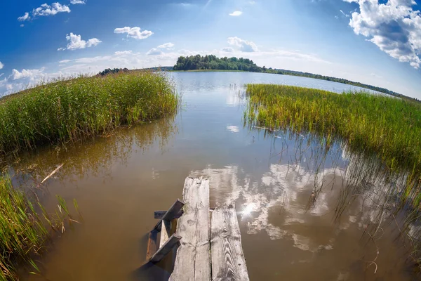 Sommar landskap med sjö och gamla träbro — Stockfoto