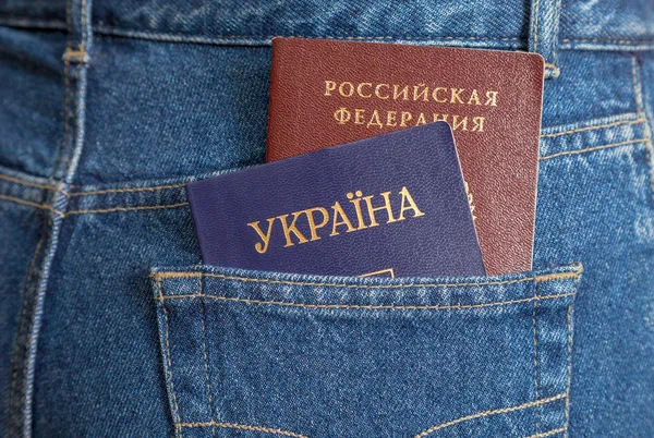 Pasaportes ucranianos y rusos en el bolsillo trasero de los vaqueros —  Fotos de Stock