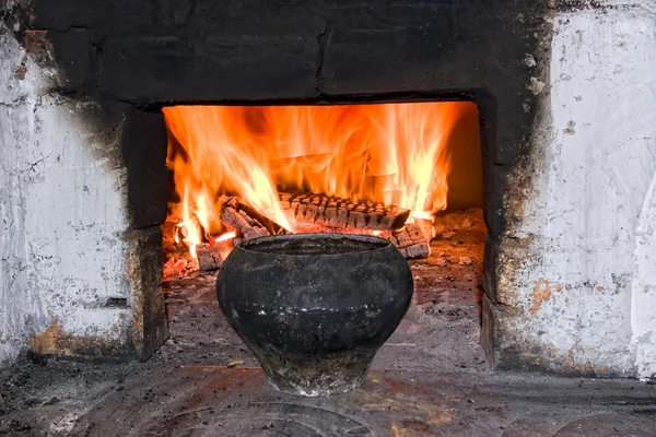 Antigua estufa rusa con olla de hierro y leña ardiente — Foto de Stock