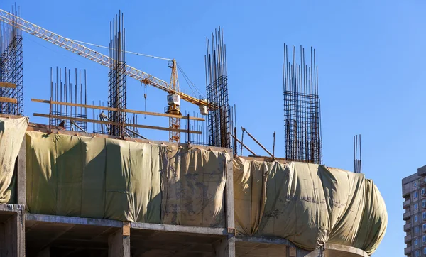 Mavi gökyüzüne karşı yapım aşamasında olan yüksek bina