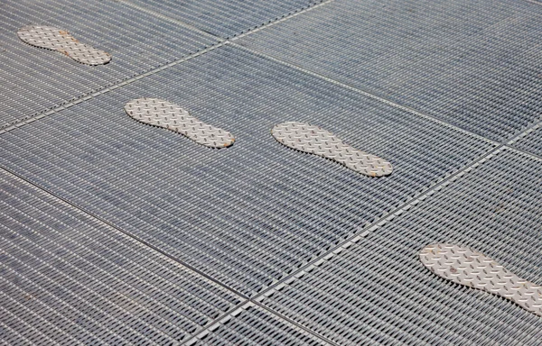 Stilisierte Spuren auf dem Metallgitter — Stockfoto