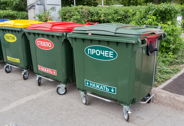 Green dumpsters on a city street with inscription on russian: " — Stock fotografie