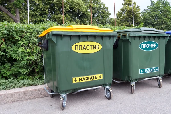 Green dumpsters on a city street with inscription on russian: " — Stock fotografie