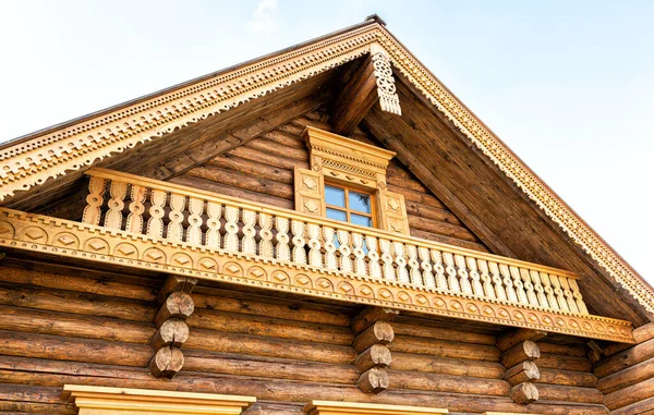 Russian traditional wooden architecture. Facade of new wooden house decorated with wooden carvings, platbands, wooden lace ornament