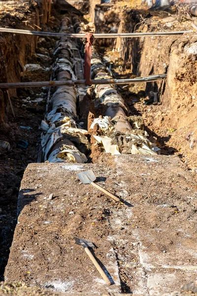 都市の暖房パイプと暖房システムの近代化の交換 発掘された溝の深さにある大きな鋼管の建設工事 — ストック写真