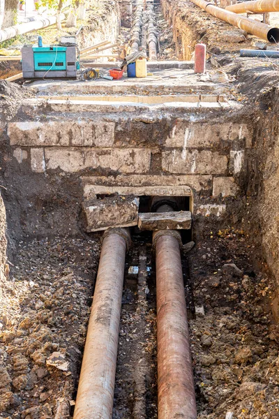 Isıtma borularının değiştirilmesi ve şehirdeki ısıtma sisteminin modernizasyonu. İnşaat, kazılmış hendek derinliğindeki büyük demir borular üzerinde çalışıyor.