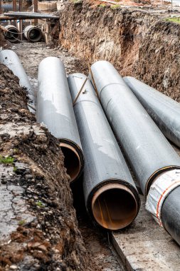 Isıtma borularının değiştirilmesi ve ısıtma sisteminin modernizasyonu. İnşaat, kazılmış hendek derinliğindeki büyük demir borular üzerinde çalışıyor.