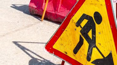Şehir caddesinde trafik tabelasında çalışıyor. Yol tabelasının altında