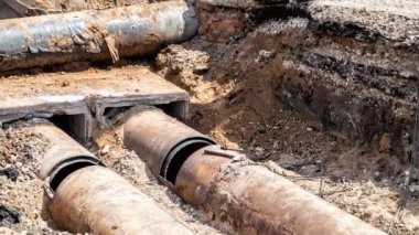 Isıtma borularının değiştirilmesi ve şehirdeki ısıtma sisteminin modernizasyonu. İnşaat, kazılmış hendek derinliğindeki büyük demir borular üzerinde çalışıyor.