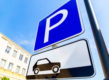 Mavi gökyüzüne karşı geniş açı manzaralı park yeri tabelası.