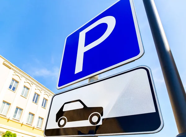 Mavi gökyüzüne karşı geniş açı manzaralı park yeri tabelası.