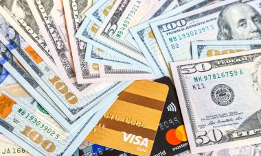 Moscow, Russia - January 4, 2021: MasterCard and Visa with american dollars banknotes