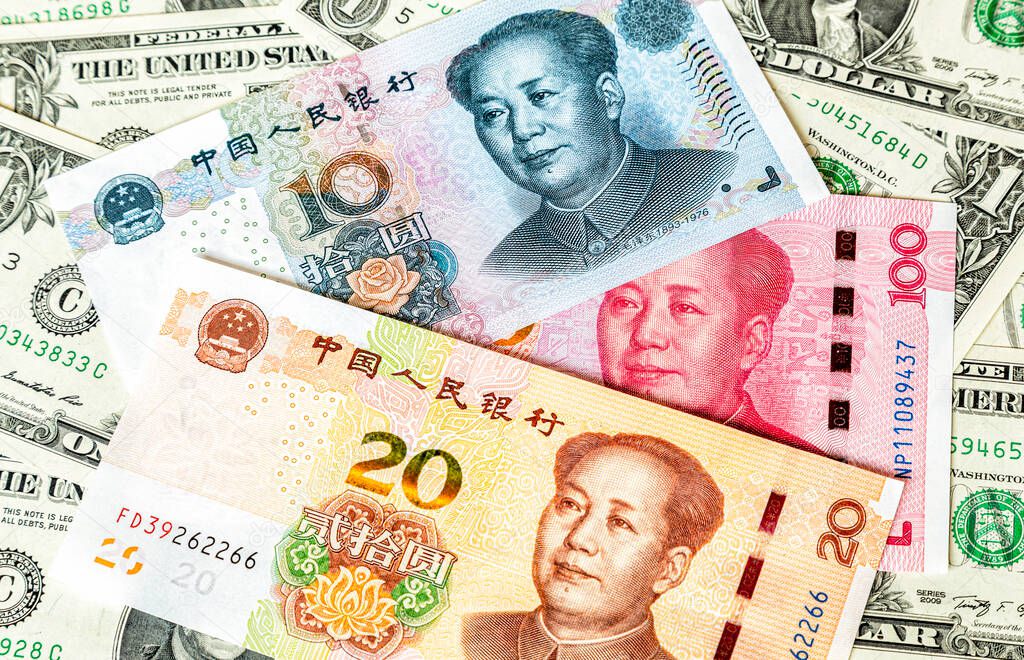 Various banknotes of Chinese currency on the dollars background. Chinese yuan paper currency. Business concept