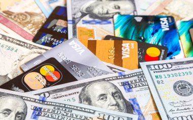 Moscow, Russia - January 4, 2021: MasterCard and Visa with american dollars and others banknotes