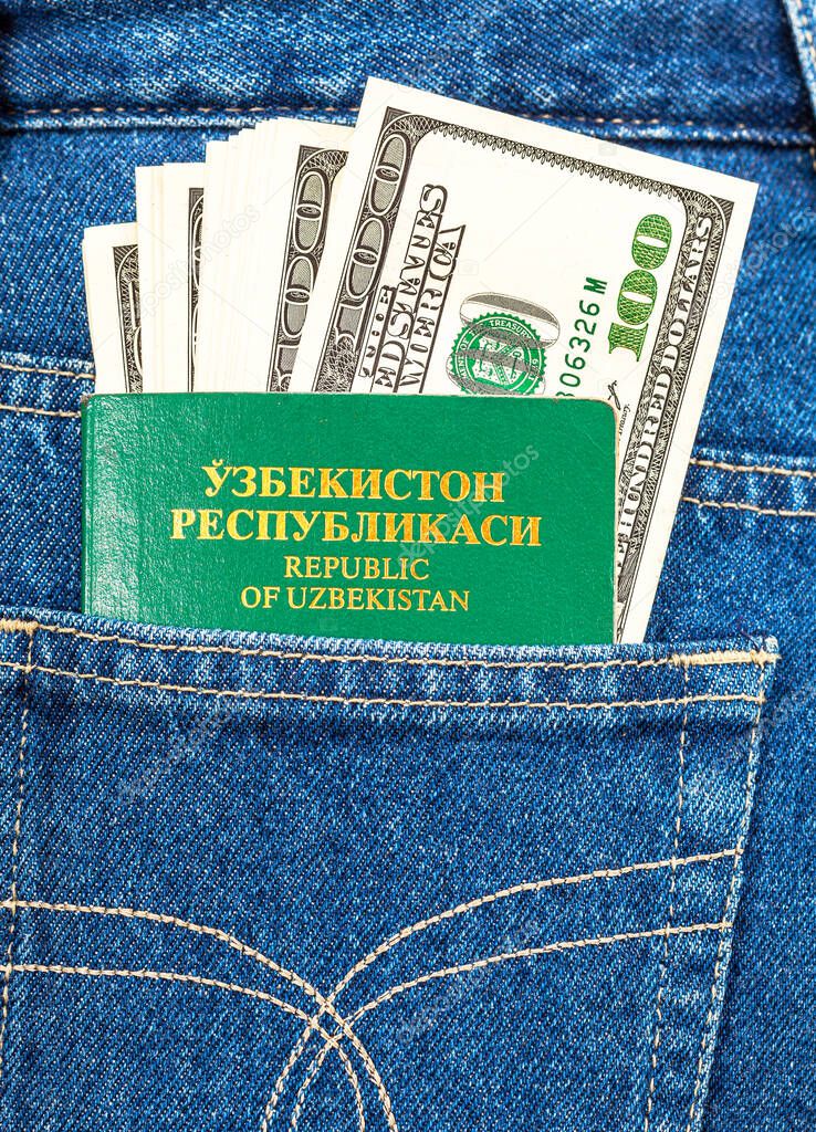 Uzbekistan passport and dollar banknotes in the back jeans pocket