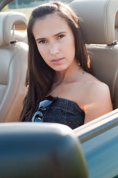 Belle femme brune assise dans la voiture — Photo