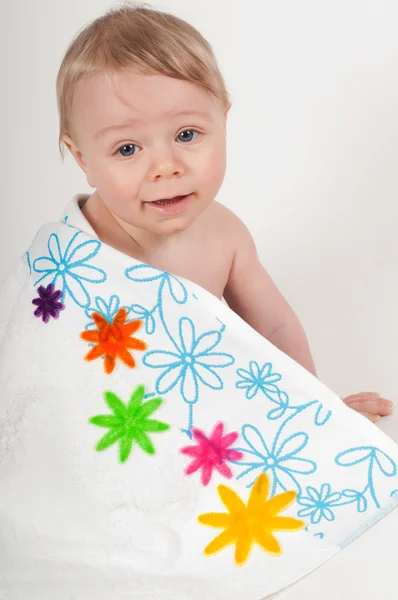 Menino em cobertor branco com flores — Fotografia de Stock