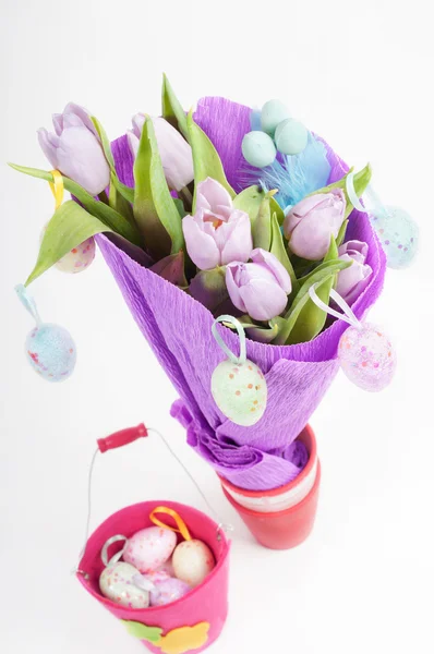 Huevos de Pascua con cubo y tulipanes — Foto de Stock