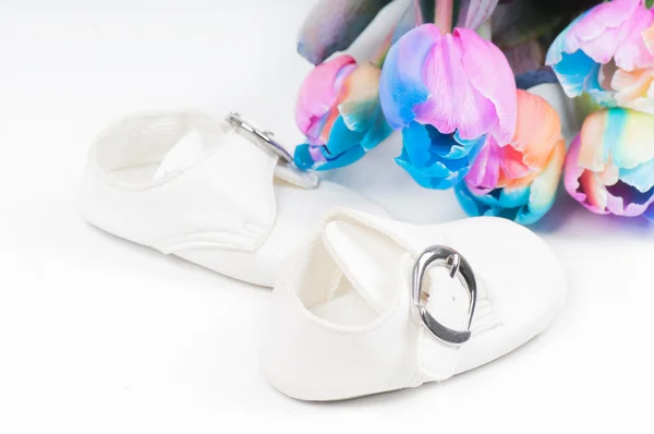 Unusual multi colored tulips and baby shoes — Stock Photo, Image