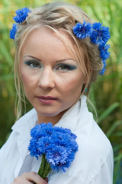 Porträtt av vacker kvinna med blå blommor — Stockfoto