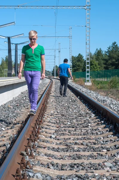 Knappe man lopen op treinrails — Stockfoto