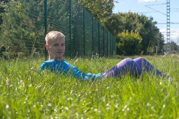 Jeune homme couché dans une herbe verte — Photo