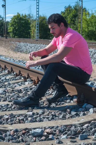 Een man in roze op trein sporen — Stockfoto