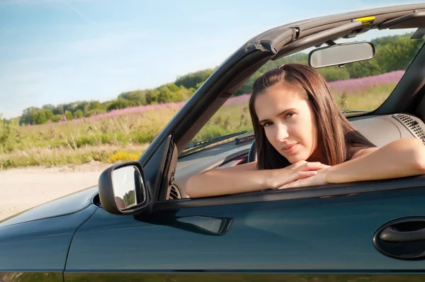 美しいブルネットの女性の車に座って — ストック写真