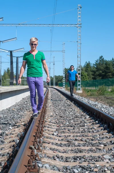 Dos jóvenes caminando por la vía férrea — Foto de Stock