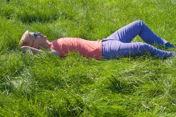 Trendy jongeman liggen op het gras — Stockfoto