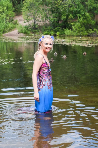 Schöne Frau in Kleid steht im Teich — Stockfoto
