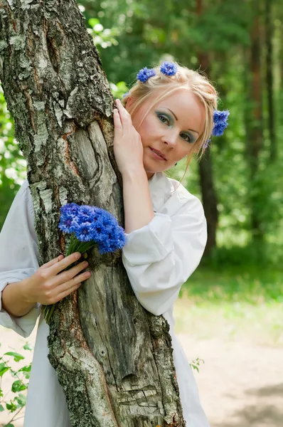 Krásná mladá žena, schovává se za strom — Stock fotografie