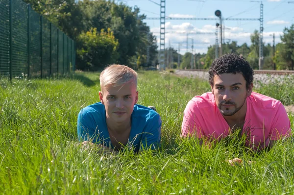 Twee knappe jonge jongens op het gras — Stockfoto