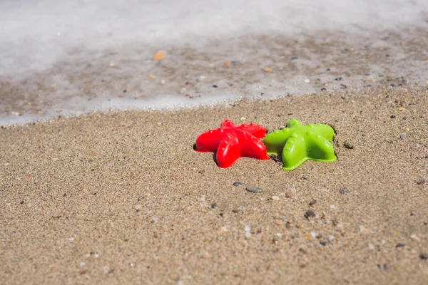 Two starfish-shaped molds on the sand — Stock Photo, Image