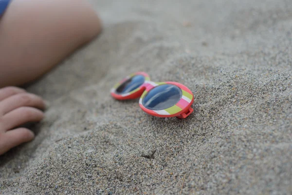 Gafas de sol a rayas en la arena — Foto de Stock