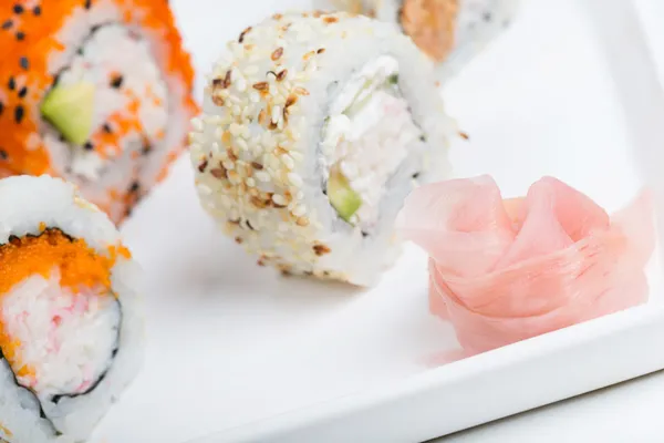 Ginger in focus and shushi on the background — Stock Photo, Image