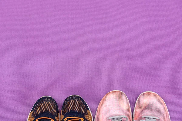 Zapatillas y una esterilla de fitness púrpura. Concepto deportivo —  Fotos de Stock