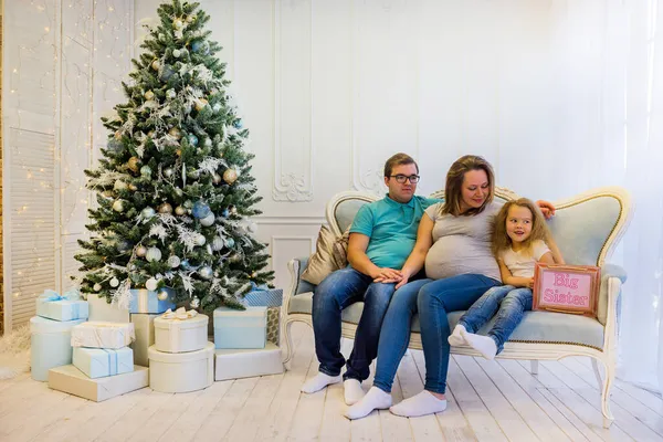 Familjeporträtt nära julgranen. Gravid kvinna — Stockfoto