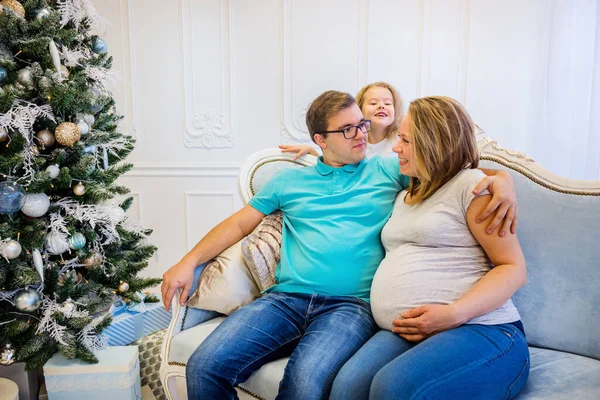 Familjeporträtt nära julgranen. Gravid kvinna. — Stockfoto