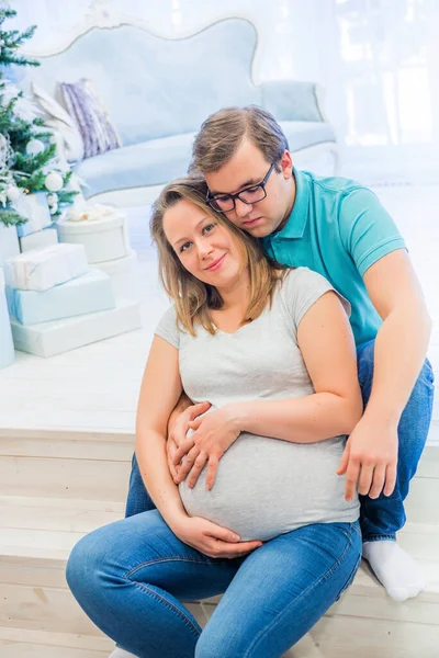 Familienporträt in der Nähe von Weihnachtsbaum. Menschen sitzen auf der Treppe — Stockfoto