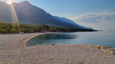 Adriyatik Denizi 'nin güzel kıyıları. Biokovo Dağı Doğa Parkı üzerinde gün doğumu ve Makarska Riviera-Biokovo, Dalmaçya, Hırvatistan ve Avrupa 'dan ağaçlar.