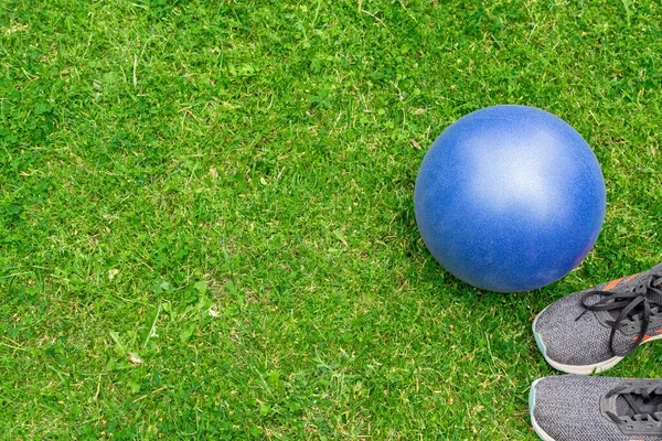 緑の芝生の背景にフィットネスボールとスニーカー トップビュー 屋外トレーニングコンセプト コピースペース — ストック写真