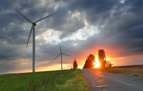 Alte Straße und Windkraftanlagen bei Sonnenuntergang — Stockfoto