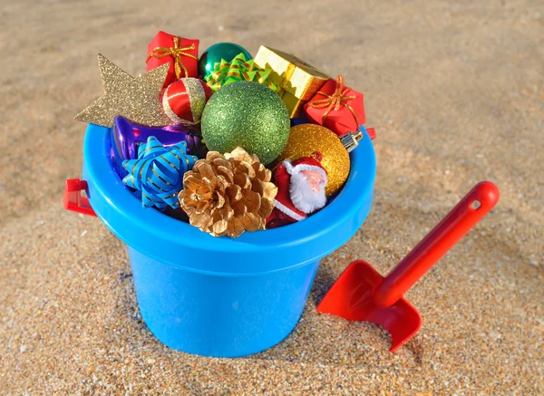 Decoraciones navideñas y juguetes en la arena de la playa —  Fotos de Stock