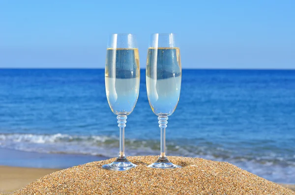 Glasses of champagne on the beach sand — Stock Photo, Image