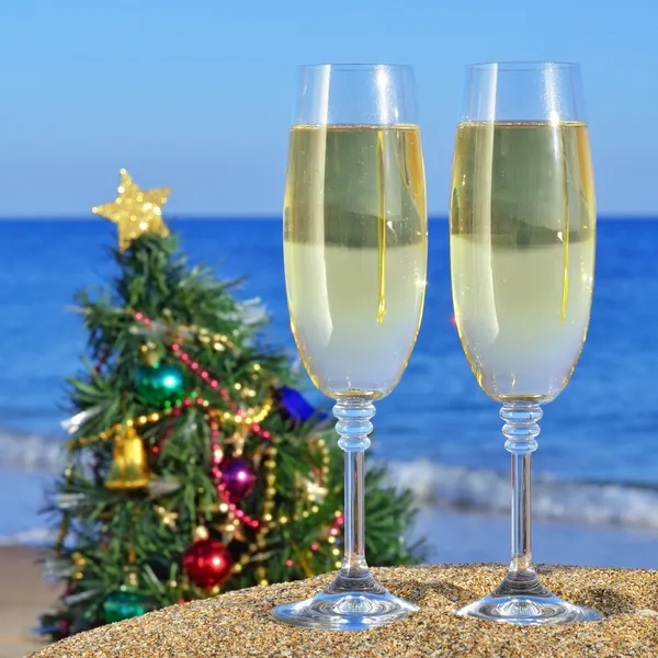 Seascape with glasses of champagne and Christmas tree on the bea — Stock Photo, Image