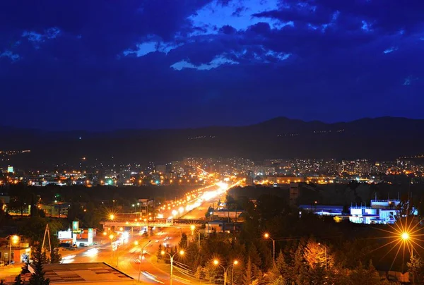 Downtown Tbiliszi és a vár narikala a hegyen, éjszaka a sötét kék ég ellen. Grúzia — Stock Fotó