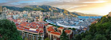 Scenic panorama of Monaco at sunrise. Beautiful view of the Monte Carlo and La Condamine quarters with seaport and yachts, surrounding mountains and the Mediterranean Sea.