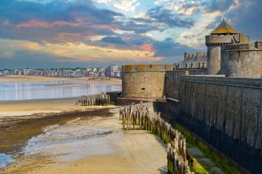 Manş Denizi kıyılarının ufuk çizgisi ve Saint-Malo şehrinin antik kale duvarları. Akşamları okyanus alçalırken dramatik bir gökyüzüne karşı. Britanya bölgesi, Fransa                           